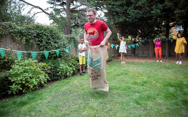 A fundraiser smiling while taking part in a sack race.