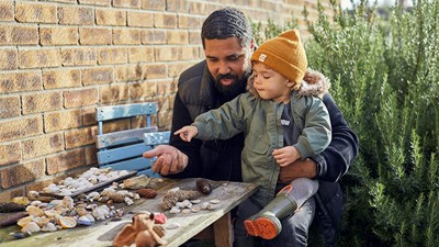A father playing with his young boy in the garden.