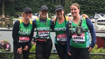 A group of Team NSPCC members smiling in their personalised running gear.