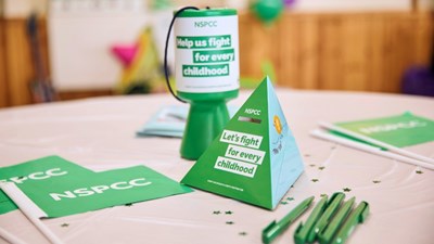 NSPCC fundraising materials and a money box on a table