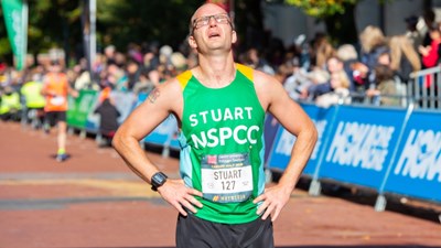 A man stops to catch his breath at the finish line of a half marathon