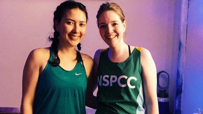 Two women wearing NSPCC vests at a yoga class