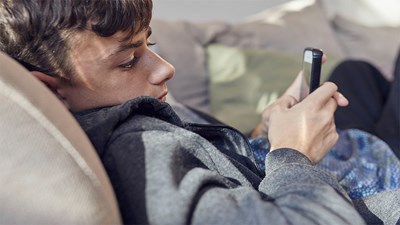 Teenage boy on sofa looking at phone